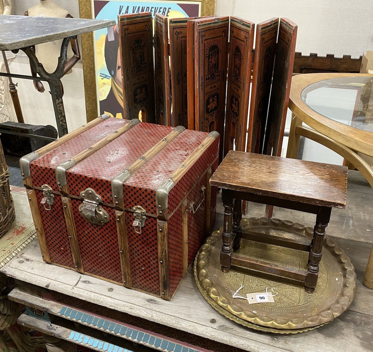 A Chinese lacquer eight fold table screen, height 67cm, an oak stool, and two engraved brass trays and a travelling trunk